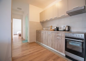 A modern kitchen with wooden cabinets, a built-in oven, and a coffee maker. - Zabljak Hills City Center-only 400m walking distance from the center (Žabljak)