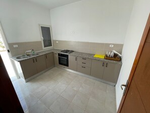 A kitchen with a gas stove, oven, sink, and cabinets. - Villa Lina, Djerba, Midoun (Djerba Midun)