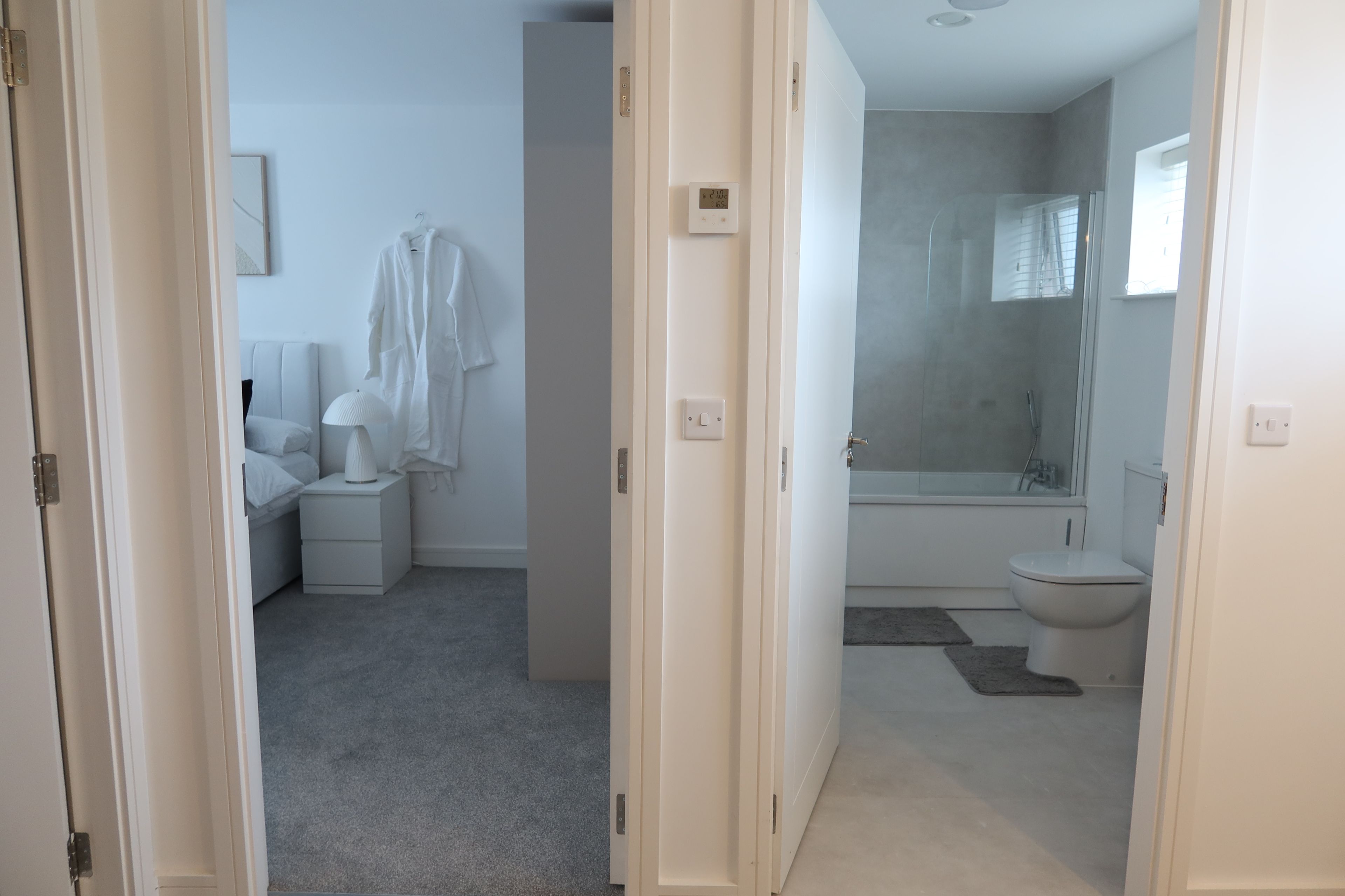 A modern bathroom with a bathtub, toilet, and shower.