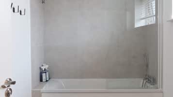 Un bagno moderno con vasca, WC e zona doccia.