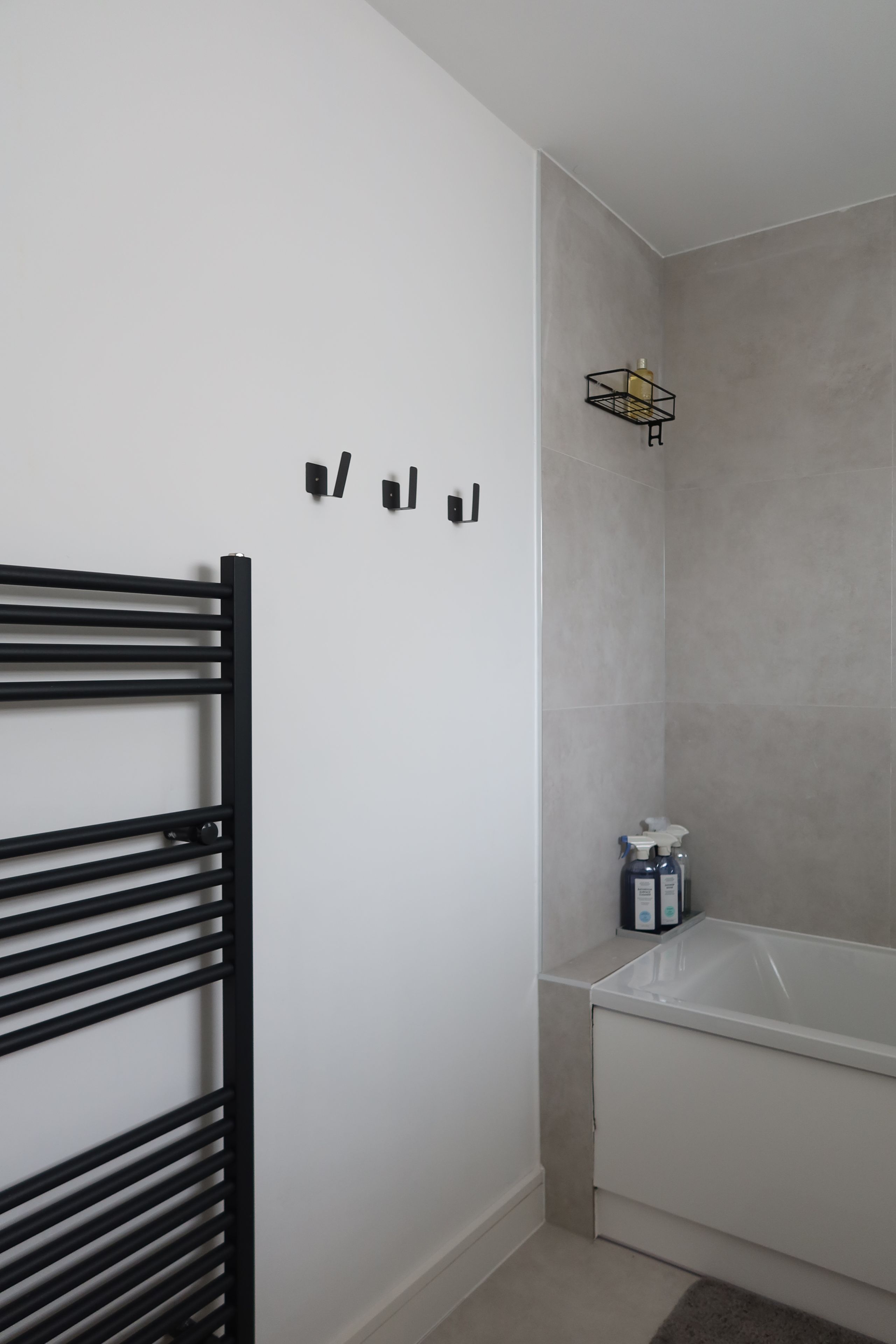 A bathroom with a bathtub, a towel rack, and a shower caddy.