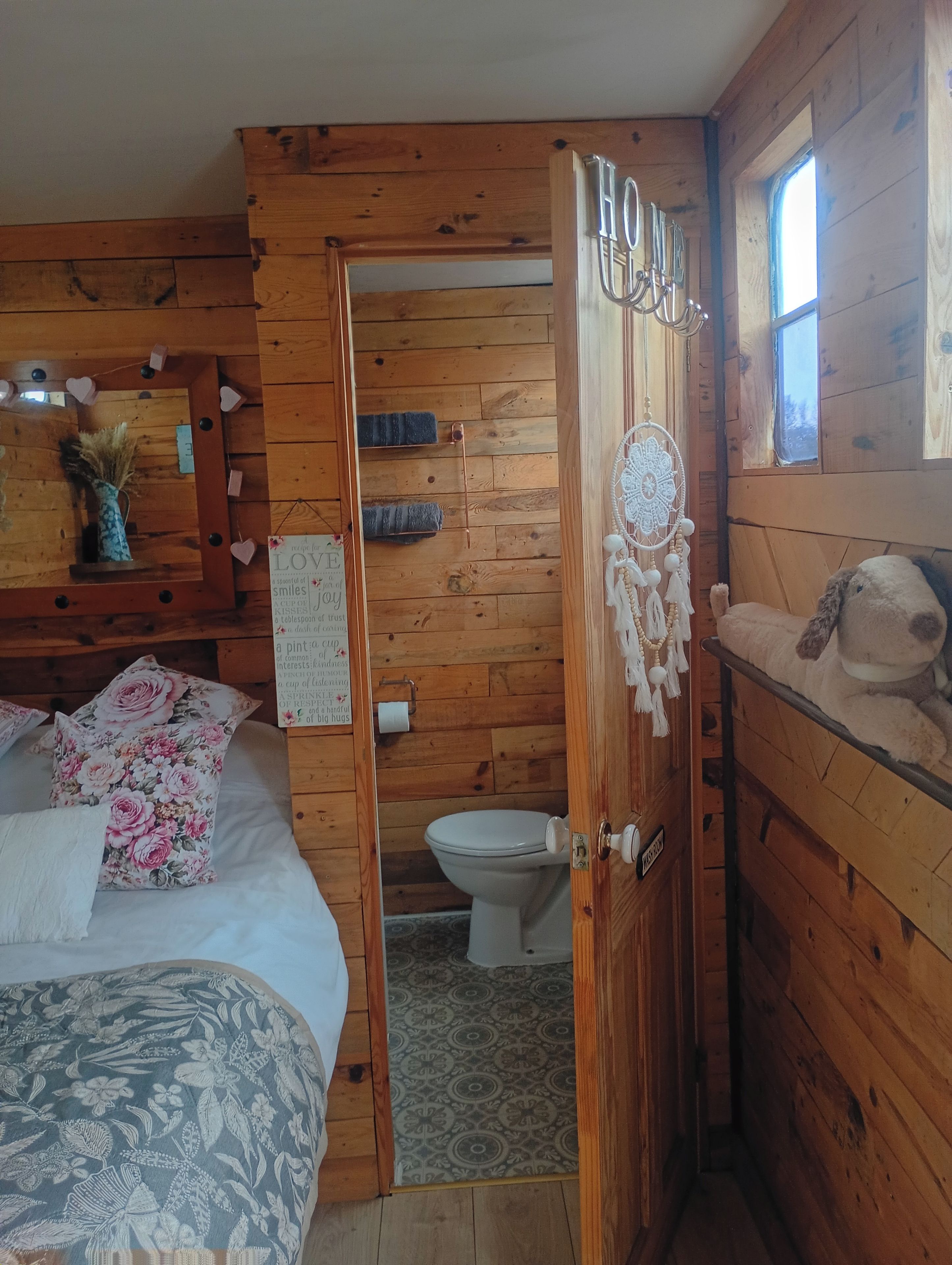 L'intérieur d'une cabane en bois, avec un lit, une salle de bain et une fenêtre.