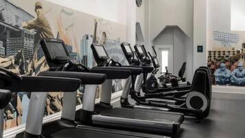 A gym with treadmills, stationary bikes, and weights.