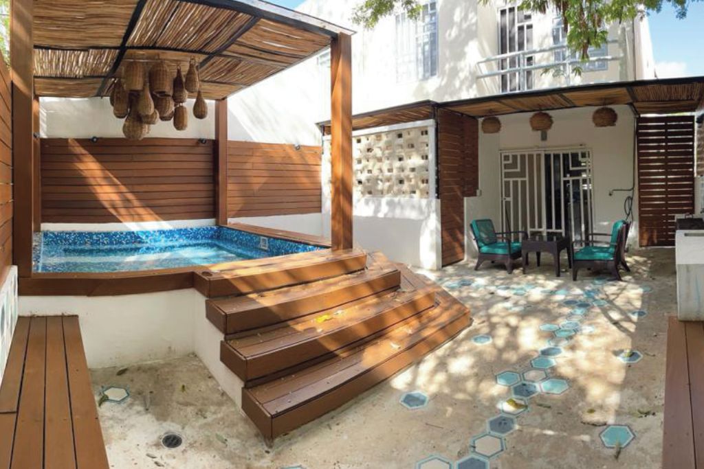 A spa area with a hot tub, wooden steps, and a seating area with chairs.