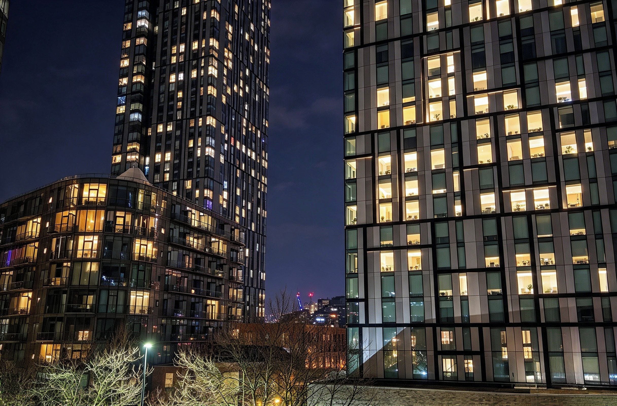 A high-rise building with multiple floors and illuminated windows at night.