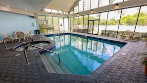 An indoor swimming pool with a hot tub, surrounded by chairs and a tiled floor. - Enclave Studio 1 mi to Universal w/ Pool (Orlando)