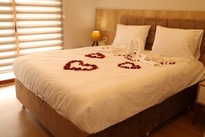 A neatly made bed with white linens and rose petals arranged on the bed. - May Villas Cet Mountain 2-1 Bungalow 207 (Ünye)