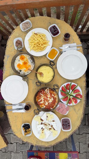 A table with various dishes including pasta, a fried egg, and a pizza. - May Villas Cet Mountain 2-1 Bungalow 209 (Ünye)