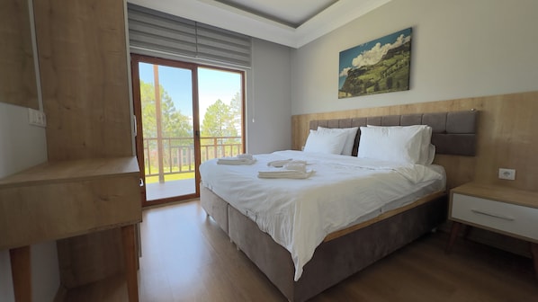 A bedroom with a large bed, a wooden headboard, a nightstand, and a painting on the wall.