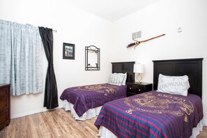 A bedroom with two beds, a wooden dresser, a mirror, and a broom on the wall. - Modern Family Condo 15min From Disney (Kissimmee)