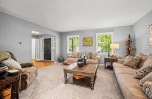 A living room with a sofa, coffee table, and a door leading to another room. - ZEN ON O'RYAN  5 BEDROOM HOUSE IN OXFORD OHIO (Oxford)