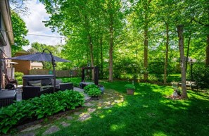 A backyard with a patio area, outdoor furniture, and a variety of plants. - ZEN ON O'RYAN  5 BEDROOM HOUSE IN OXFORD OHIO (Oxford)