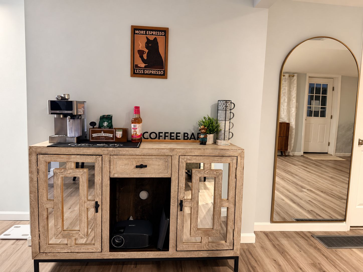 Un meuble en bois sur lequel sont posés une machine à café, un paquet de café et une tasse à café.