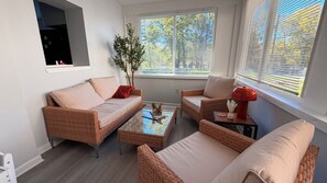 A modern living room with a sofa, two armchairs, a coffee table, and a side table with decorative items. - Willow Terrace House (Mechanicsburg)