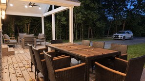 An outdoor patio with a table and chairs, a covered seating area, and a car parked in the background. - Willow Terrace House (Mechanicsburg)
