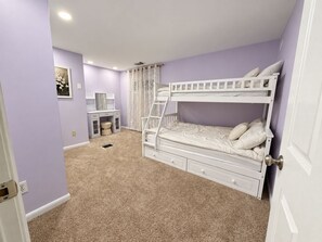 A bedroom with a bunk bed, a desk with a chair, and a small cabinet. - Willow Terrace House (Mechanicsburg)
