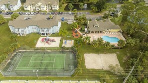 An aerial view of a residential area with a tennis court, a swimming pool, and a playground. - 3BR Condo Royal Bay Near Disney + Resort (Kissimmee)