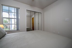 A bedroom with a large bed, a window, and a sliding door leading to another room. - 3BR Condo Royal Bay Near Disney + Resort (Kissimmee)