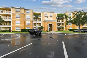 A multi-story residential building with a central entrance and a parking lot. - 3BR Vista Cay Condo Near Universal (Orlando)