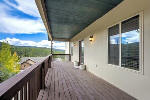 En træterrasse med udsigt over et bjergrigt landskab.