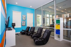 Ein Zimmer mit blauen Wänden, einem großen Fenster und Trainingsstühlen.