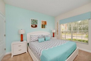 A bedroom with a bed, two bedside tables, and a window with blinds. - 4BR Townhome w/ Private Pool at Paradise Palms (Kissimmee)