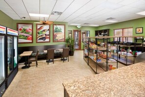 A restaurant with a counter, seating area, and a display of food items. - 4BR Townhome w/ Private Pool at Paradise Palms (Kissimmee)