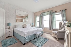 A bedroom with a bed, bedside tables, a chair, and a dresser. - Solterra 4BR Home w/ Private Pool (Davenport)
