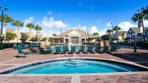 A swimming pool with lounge chairs, a building with a gabled roof, and palm trees. - 3BR Home at Seven Dwarfs Resort w/ Pool (Kissimmee)