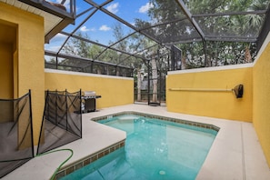 A swimming pool with a glass ceiling, surrounded by yellow walls and a covered patio area. - 4BR Paradise Palms Townhome, Heated Pool (Kissimmee)