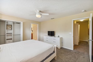 A bedroom with a bed, a TV on a dresser, a ceiling fan, and a closet. - 4BR Paradise Palms Townhome, Heated Pool (Kissimmee)