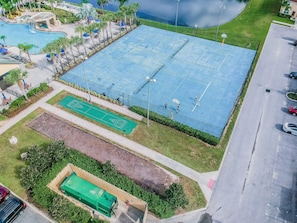 A large outdoor sports area with multiple courts, a swimming pool, and a green tennis court. - 4BR Paradise Palms Townhome, Heated Pool (Kissimmee)