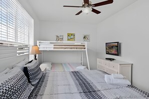 A bedroom with a bunk bed, a desk, a chair, a TV, and a ceiling fan. - Vista Cay 3BR Townhome Near Universal & Occc (Orlando)