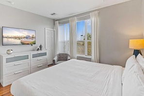 A hotel room with a large bed, a TV on the wall, a dresser, and a chair. - 3-bedroom Condo at Vista Cay Near Disney (Orlando)