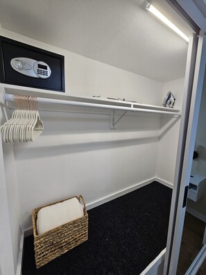 Un lit superposé avec une tête de lit blanche, une petite étagère au-dessus et un panier en dessous.