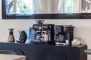 A coffee station with a Keurig machine, a coffee grinder, a bag of Hawaiian coffee, and a coffee pot on a counter. - Sunset View Updated Villa Heated Pool  Kings (Waikoloa Village)