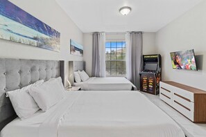 A hotel room with two beds, a television, a slot machine, and artwork on the walls. - Spacious 3BR Condo at Vista Cay Resort (Orlando)