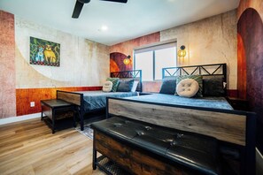 A room with a bed, a bench, and a small table. - Casa Frida | 7BR Spanish Estate w/ Pool, Spa & Cabanas (Coachella)