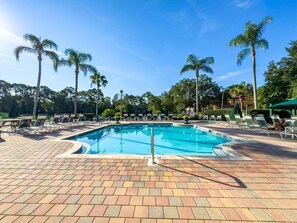 A swimming pool with lounge chairs and palm trees. - 5BR Emerald Island Pool Home, Game Room (Kissimmee)