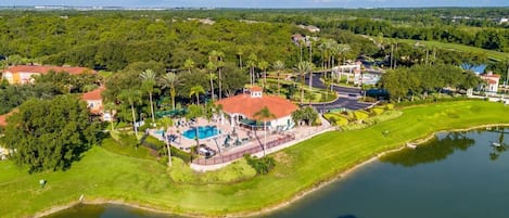 Vista aérea de un resort con piscina, campo de golf y lago.