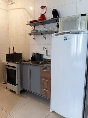 A kitchen with a stove, oven, microwave, and a refrigerator. - Charming loft 850 m from Unicesumar. (Maringá)