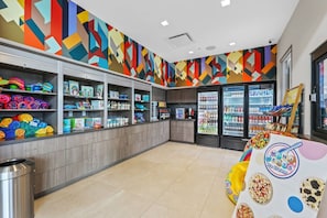 A colorful ice cream shop with a variety of products on shelves and in freezers, and a table displaying ice cream options. - Modern 5BR Villa w/ Pool 15 min to Disney (Orlando)