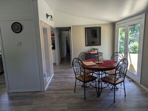 A dining area with a round table, four chairs, and a buffet stand. - Cozy 2-bdrm house in Cottage Grove with Fenced Yard, Plenty of Parking (Cottage Grove)