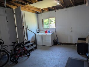 A laundry room with a washing machine, a bicycle, and a window. - Cozy 2-bdrm house in Cottage Grove with Fenced Yard, Plenty of Parking (Cottage Grove)