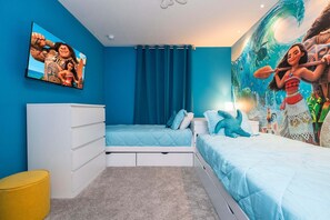 A bedroom with a bed, a dresser, a wall-mounted TV, and a mural. - Themed 4BR Townhome w/ Pool at Solara (Kissimmee)