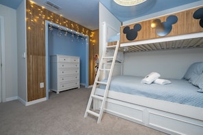 A bunk bed with a Mickey Mouse headboard, a dresser, and fairy lights on the wall. - 4BR Home w/ Pool at Paradise Palms Near Disney (Kissimmee)