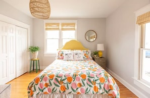 A bedroom with a bed, a window with blinds, a bedside table with a lamp, and a hanging light fixture. - Cozy 3 bedroom home in historic Cleveland walking distance from Lee University (Cleveland)