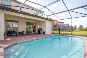 A swimming pool with a patio area, a covered seating area, and a view of the surrounding landscape. - BR Villa w/ Pool, Star Wars Game Room + Resort (Davenport)