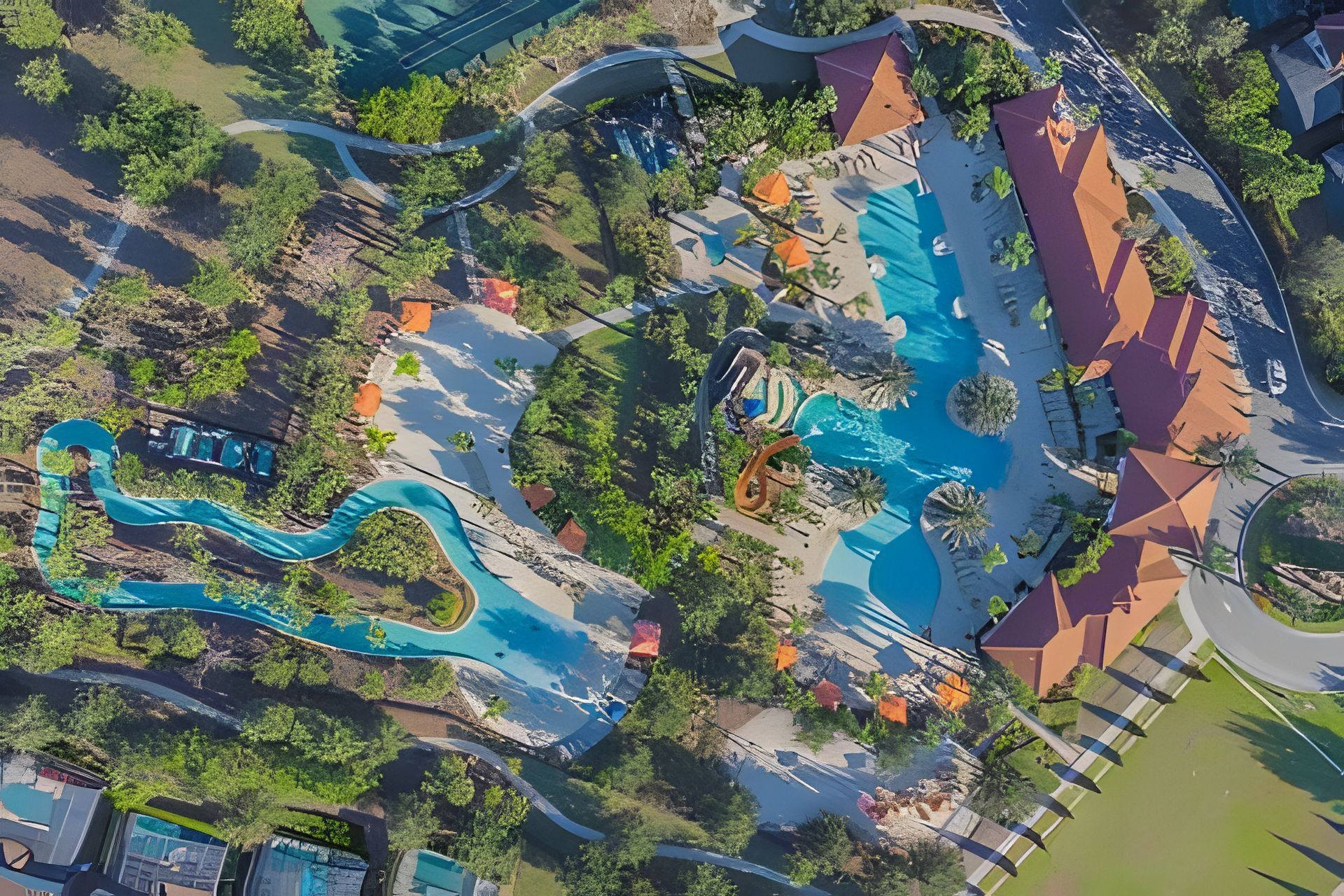 An aerial view of a resort with multiple swimming pools, winding walkways, and lush greenery.