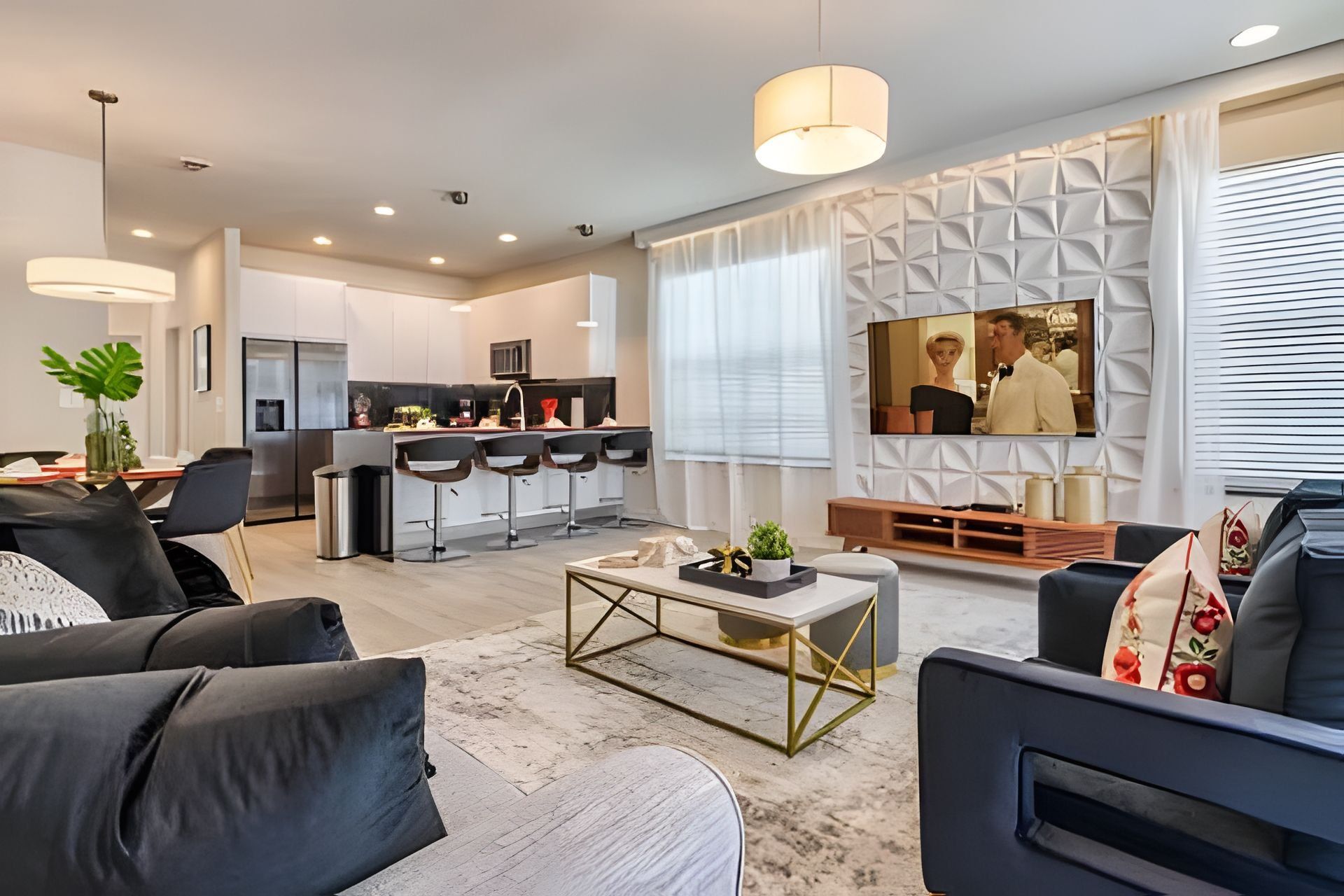 A modern living room with a sofa, coffee table, and TV wall.